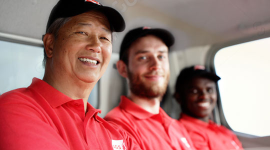 3 movers smiling in a truck