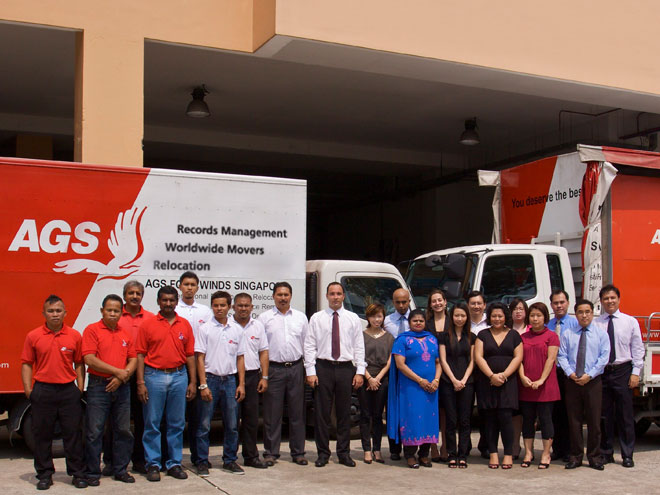 AGS Singapore staff posing in front of their facilities with trucks