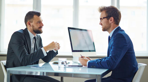 2 men meeting in an office with a computer