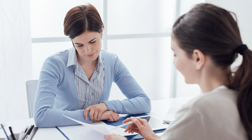 Two women meeting and filling a contract