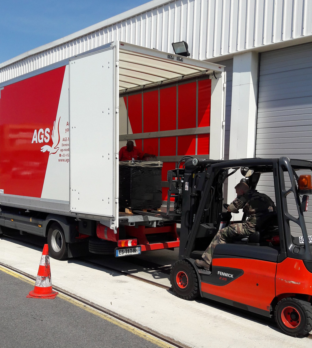 Forklift loading supplies into an AGS moving truck.