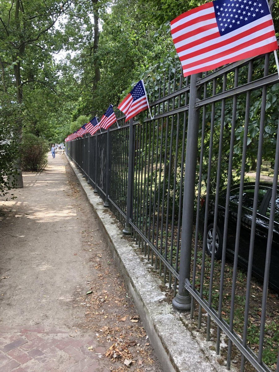 Gate lined with small American Flags along a walkway.